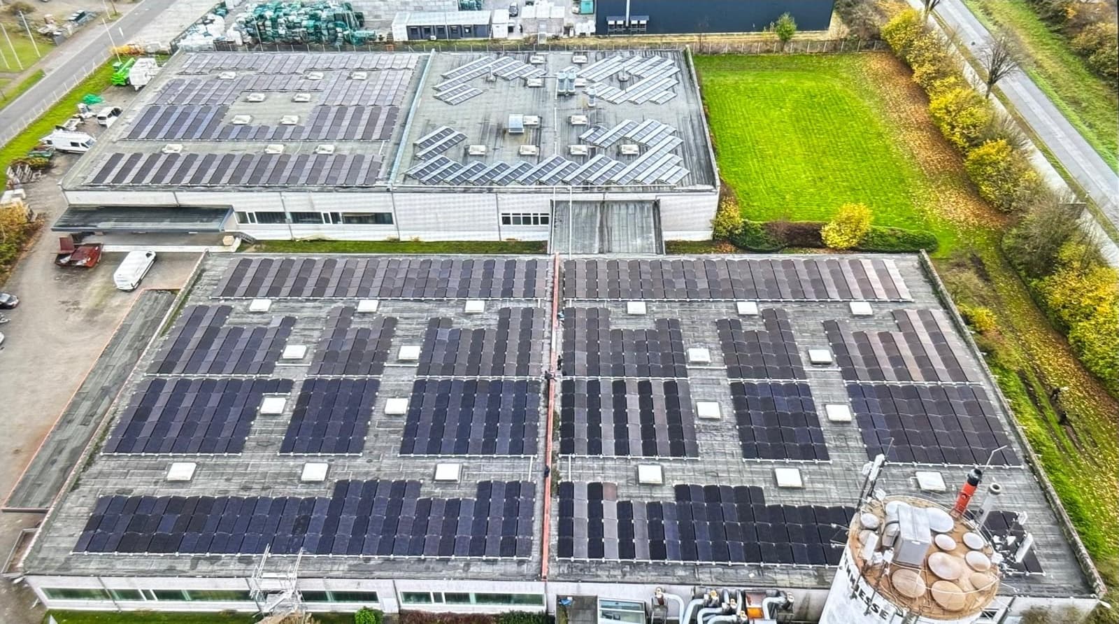 Luftaufnahme großer mit Photovoltaik belegter Hallendächer